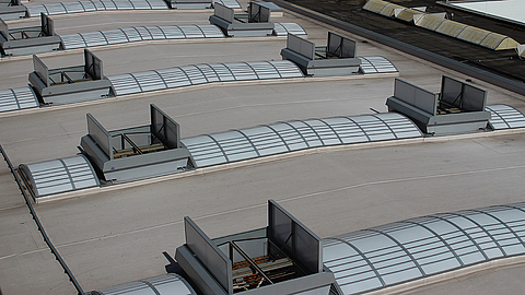 Multiple ventilation systems on the flat roof of an industrial building